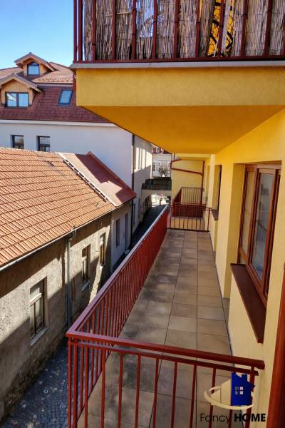 Balkon 2-pokojového bytu na Kostelním náměstí v Kežmarku s výhledem na střechy.