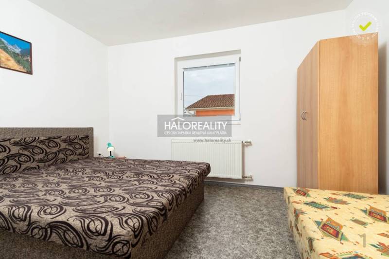 Pokoj v hotelu nebo penzionu s jedinečným vzorem postele a nástěnným obrazem.