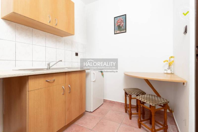 Kuchyňský kout v hotelech a penzionech s dřevěným dekorem a malým stolkem.