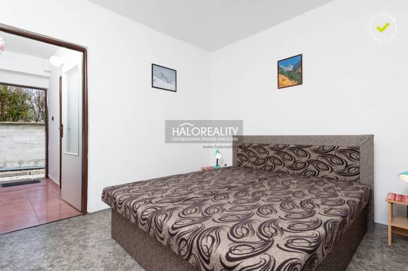 Ložnice s manželskou postelí, bílými stěnami a obrazy v hotelu a penzionech.