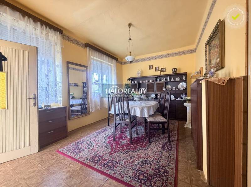 Jídelna v rodinném domě s podlahou s dřevěným dekorem, zdobený koberec a stůl.