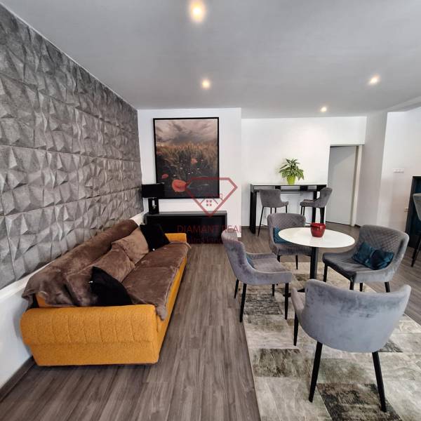 Obývací pokoj v rodinném domě s pohodlnou sedačkou a jídelními židlemi.