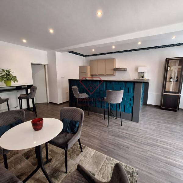 Interiér rodinného domu s barovým pultem, jídelním stolem a pohodlnými židlemi.