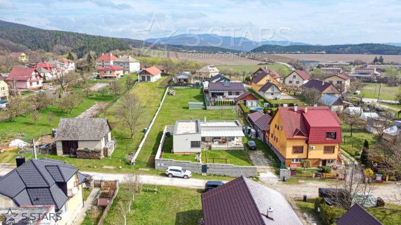Rodinné domy na Bošianské ulici v Neporadzi obklopené zelení a pohořími.
