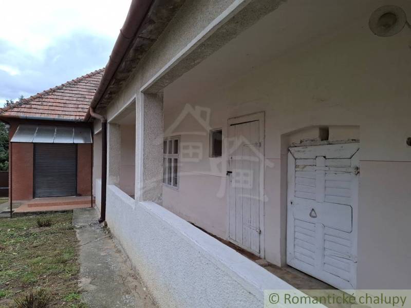 Rodinný dům v Mužli s bílou fasádou a šikmou střechou z červené krytiny.