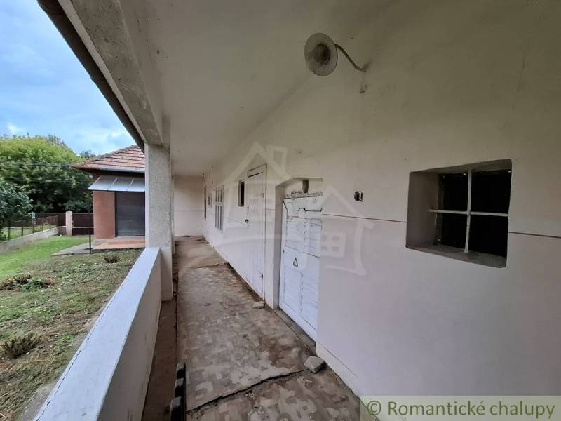 Veranda rodinného domu v Mužli s bílou fasádou a travnatým dvorem.