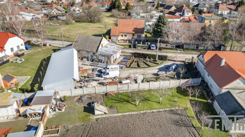 Obchodní prostory v Okoči s okolními domy v klidné venkovské oblasti.