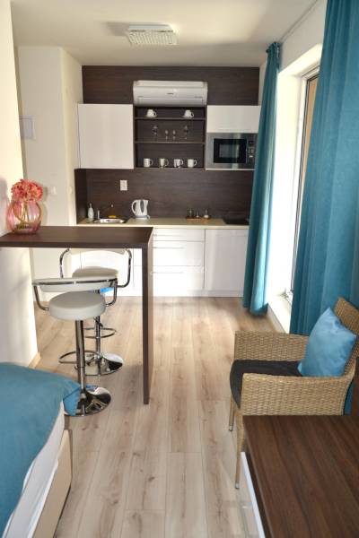 Kuchyně v 2-pokojovém bytě s barovým pultem a podlahou s dřevěným dekorem.