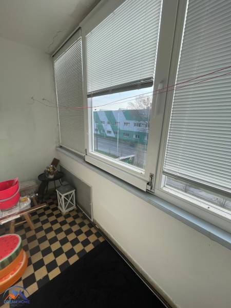 Zasklený balkon s výhledem na ulici a šachovnicovou podlahou v Hurbanově.