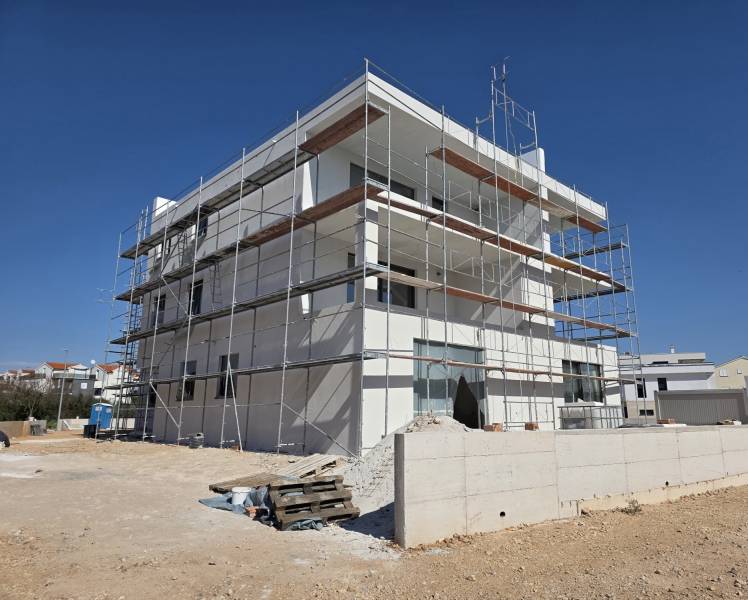 Budova v SRIMA s lešením, pracuje se na 3pokojovém bytě.