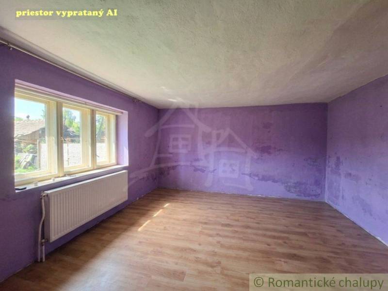 Prázdná místnost s fialovými stěnami v rodinném domě, podlaha s dřevěným dekorem.