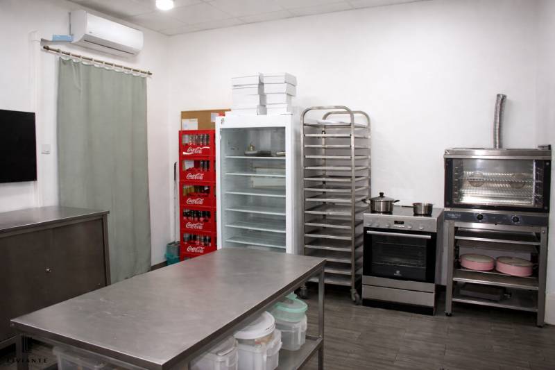 Kuchyňské gastro prostory s lednicí, troubou, regály a zásobníkem na nápoje.
