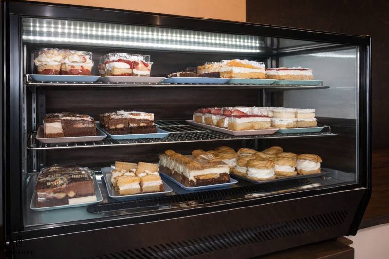 V gastro prostorech jsou v lednici vystaveny různé druhy zákusků.
