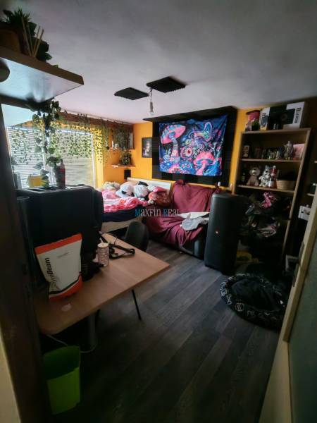 Pokoj v rodinném domě s pestrobarevnou dekorací a podlahou s dřevěným dekorem.