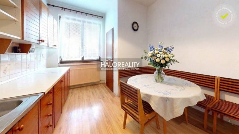 Kuchyně v rodinném domě s podlahou s dřevěným dekorem a květinovou výzdobou.