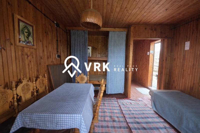 Dřevěný interiér s jídelním stolem, pohovkou a závěsy, Pozemky - bydlení.