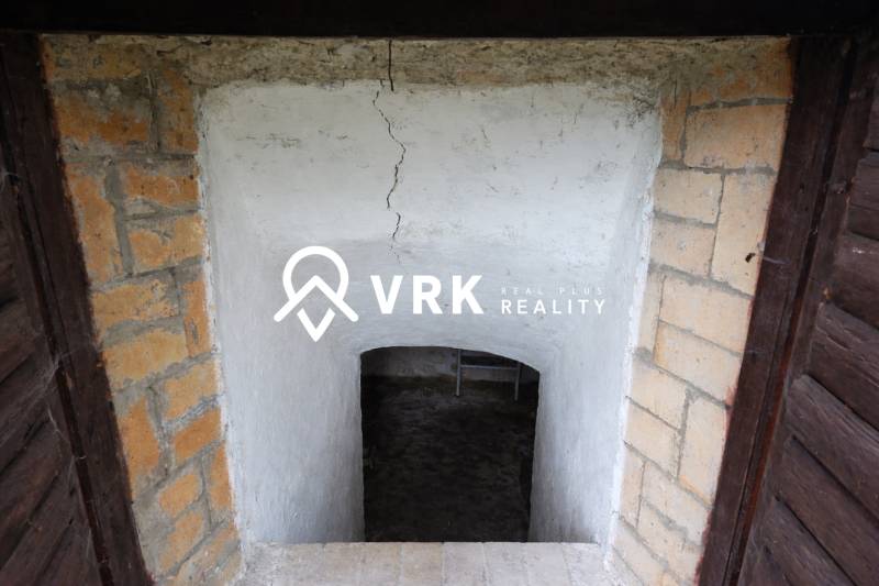 Vchod do sklepního prostoru s omítnutými stěnami a cihlovým rámem, Pozemky - bydlení.