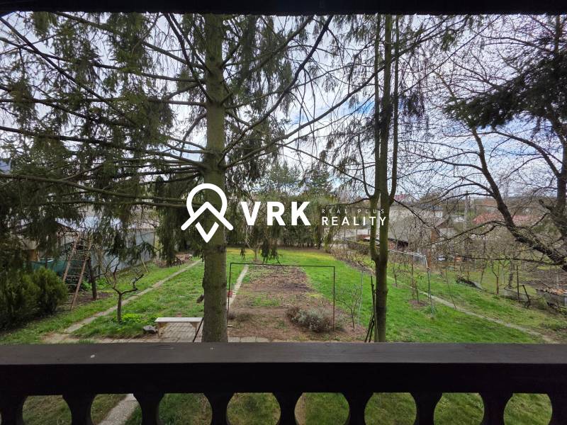 Pohled na zelený pozemek v Bohdanovicích obklopený stromy pro bydlení.