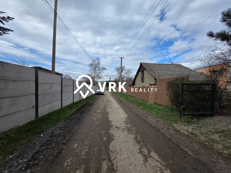 Venkovská cesta v Bohdanovicích, s pozemky pro bydlení na obou stranách ulice.