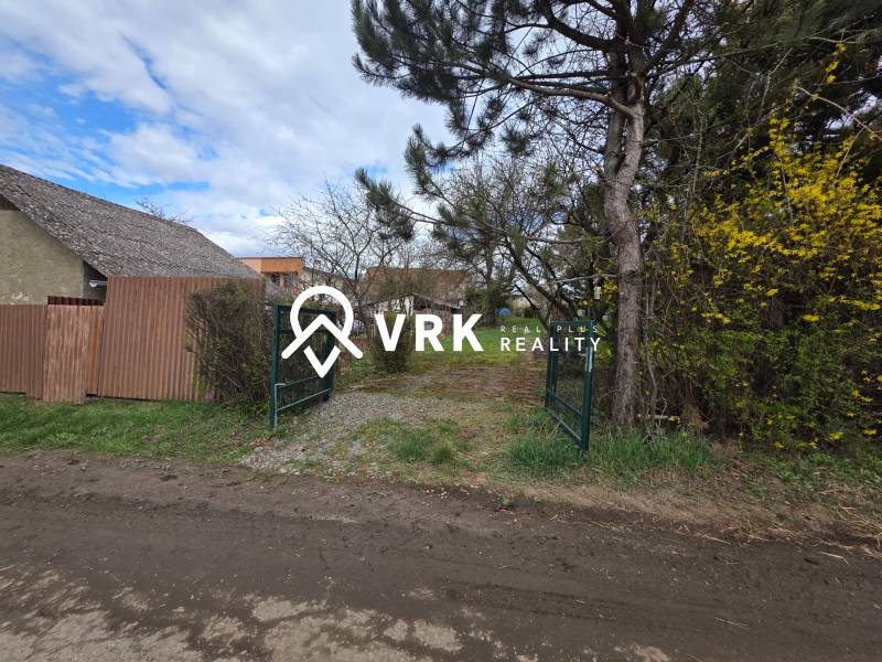 Brána obklopená zelení a plotem na Pozemky - bydlení v Bohdanovicích.