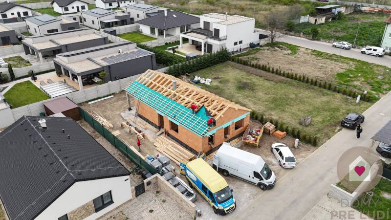 Výstavba rodinného domu na Karasově ulici v Senci, obklopeného hotovými domy.