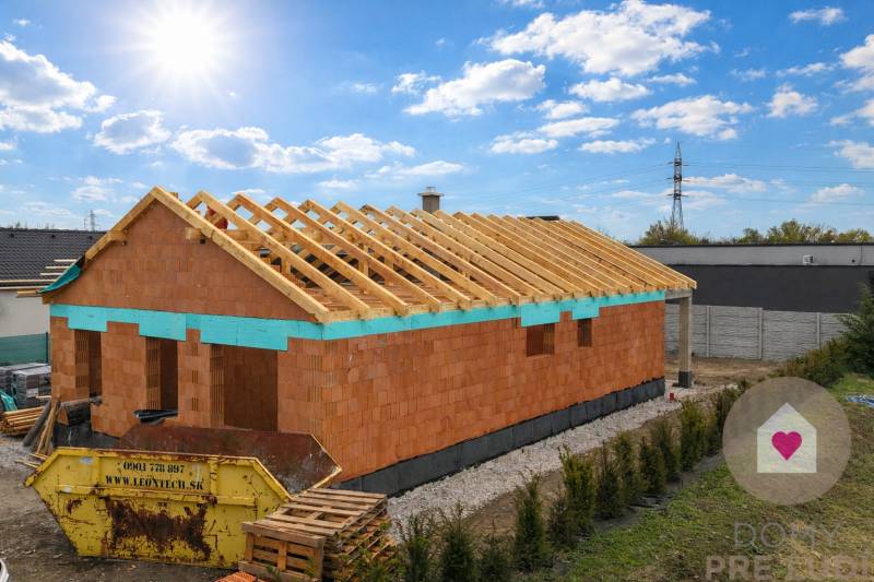 Rozestavěný rodinný dům na Karasově ulici v Senci s viditelnou střešní konstrukcí.