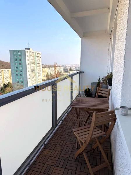 Balkon 3-pokojového bytu na Púpavové ulici v Bratislavě - Karlova Ves s dřevěným dekorem podlahy.