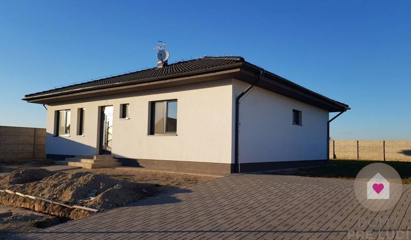 Rodinný dům na Jelšové ulici v Bernolákově s bílo-šedou fasádou a dvorem.