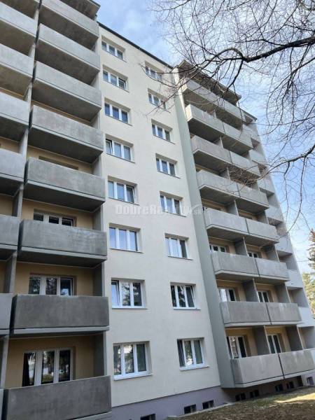 Bytový dům na ulici T. Vansové v Prievidzi s balkóny a šedou fasádou.