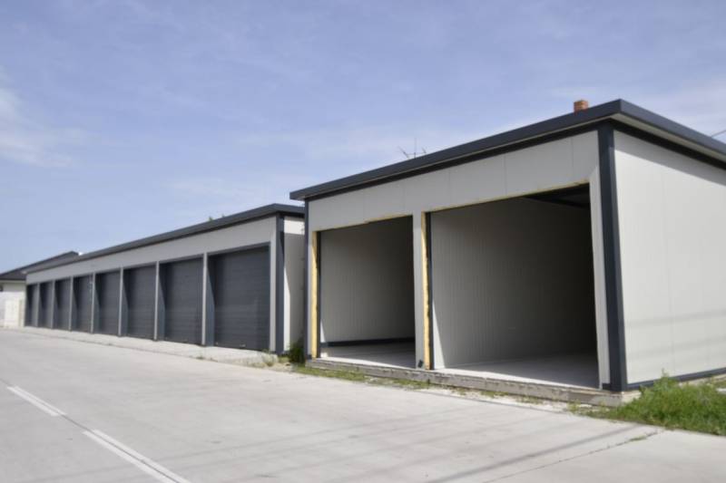 Garáže v Michale na Ostrově se šedou fasádou a otevřenými vraty.