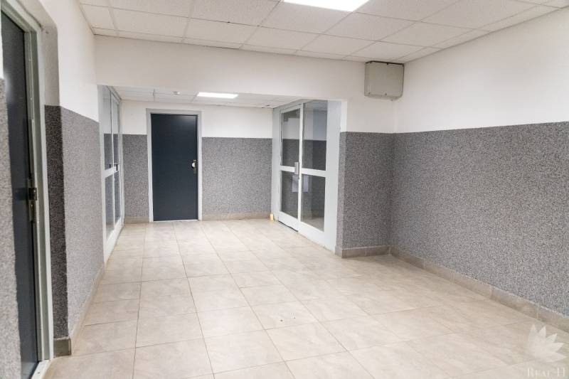 Chodba s dlažbou a bílými stropními panely ve 4-pokojovém bytě.