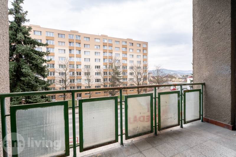 Balkon 3-pokojového bytu v Dubnici nad Váhom s výhledem na bytový dům a zeleň.