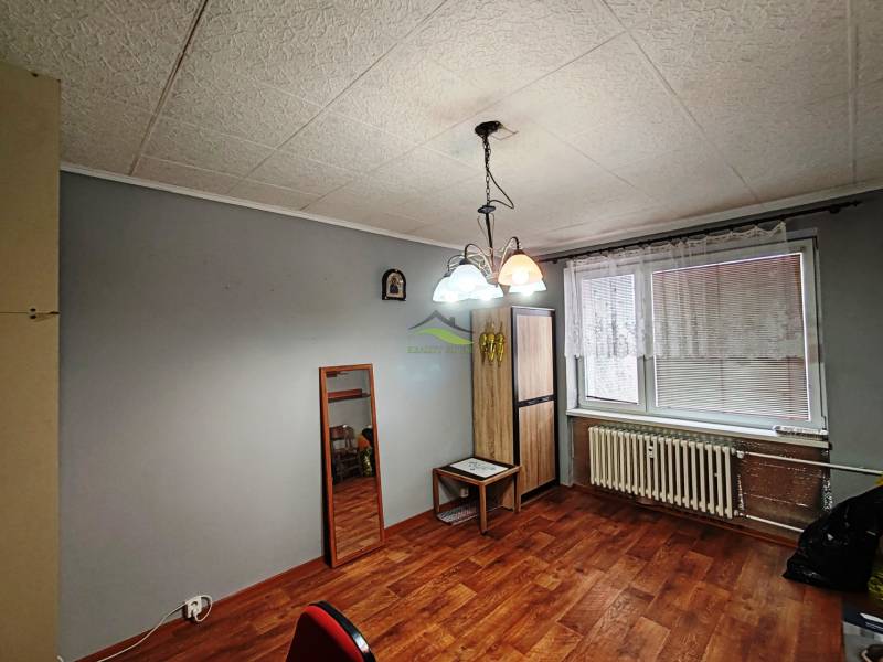 Šedé stěny ve 4-pokojovém bytě s podlahou s dřevěným dekorem a lustry.