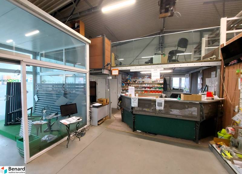 Obchodní prostory se skleněnou stěnou a pracovním prostorem, podlaha s dřevěným dekorem.