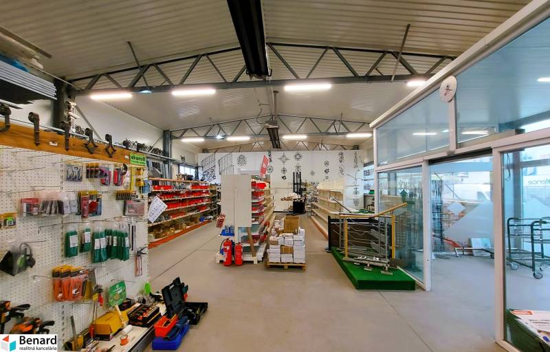 Obchodní prostory obsahující regály se zbožím, police a stojany s firemními reklamami.