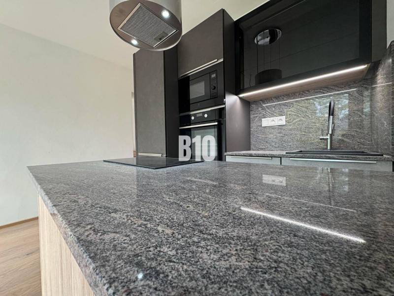 Kuchyně v 2-pokojovém bytě s mramorovou deskou a moderním vybavením.