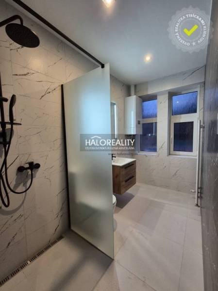 Koupelna v 2-pokojovém bytě s vanou a sprchou, obklady s imitací mramoru.