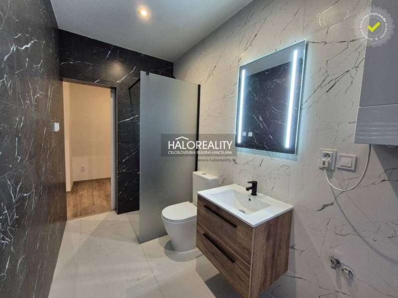 Koupelna v 2-pokojovém bytě s černým mramorem a podlahou s dřevěným dekorem.