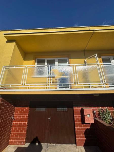 Rodinný dům v Nových Zámcích na ulici Nové Zámky s balkonem a cihlovým obkladem.