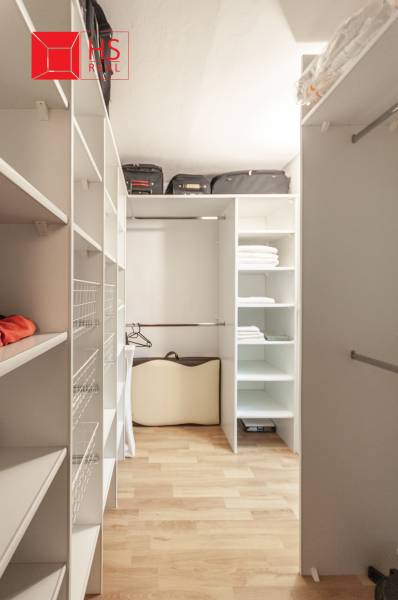 Šatník s regály a podlahou s dřevěným dekorem ve 3-pokojovém bytě.