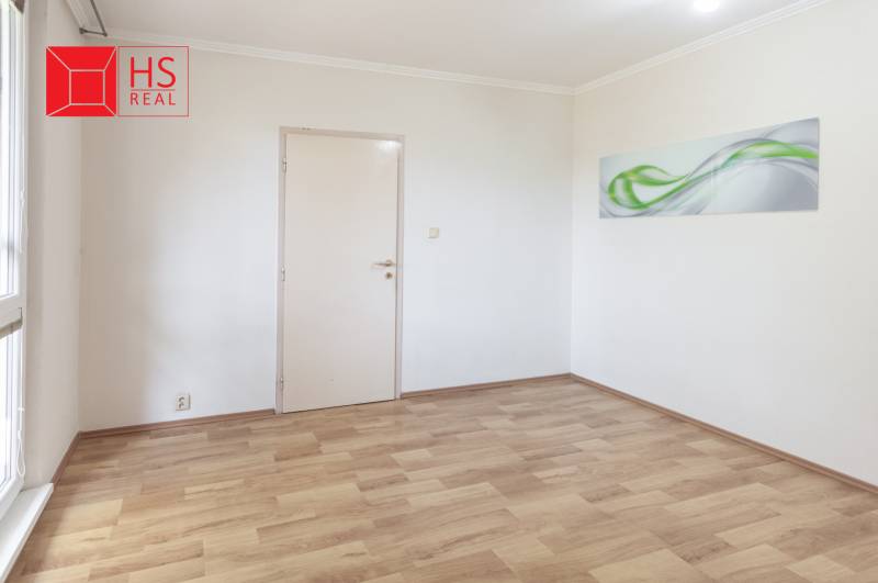 Prázdná místnost s dekorativním obrazem a podlahou s dřevěným dekorem ve 3-pokojovém bytě.