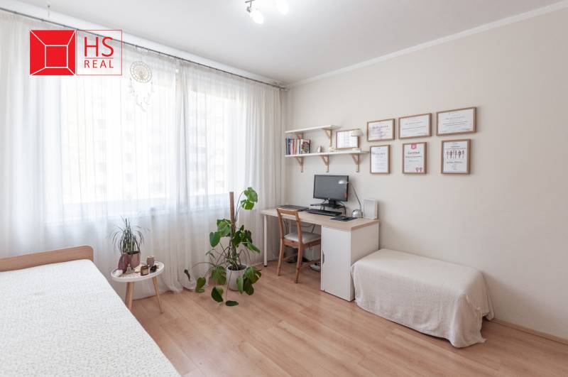 Pracovní kout s dřevěným dekorem podlahy a nábytkem v 3-pokojovém bytě.