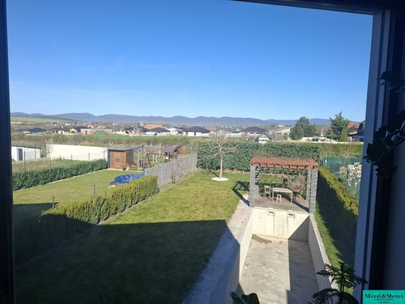 Zahrada rodinného domu ve Zvončíně s altánkem a bazénem, výhled na kopce.