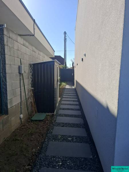 Úzká boční cestička se štěrkem v Rodinném domě ve Zvončíně.