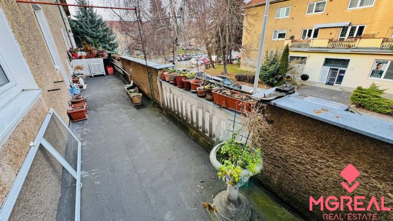 Balkón s květináči a výhledem na ulici F. Madvu v Prievidzi nabízí klidné prostředí.