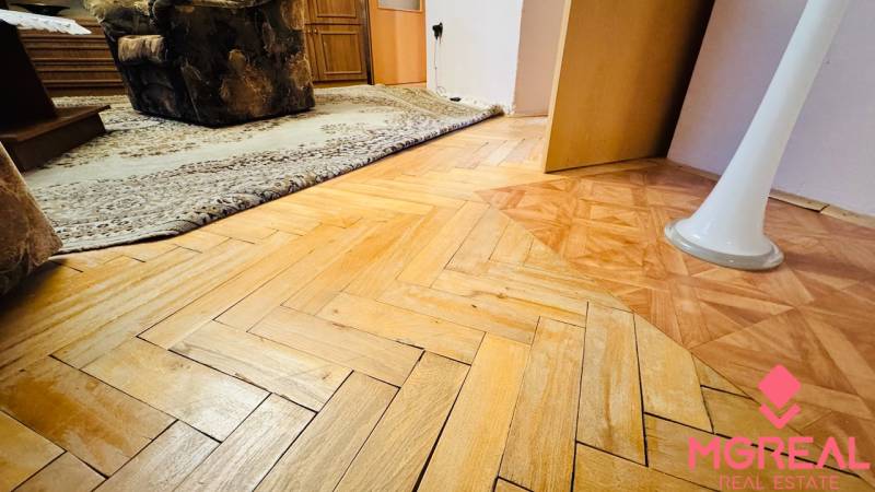 Podlaha s dřevěným dekorem v 3-pokojovém bytě, koberec a nábytek v interiéru.