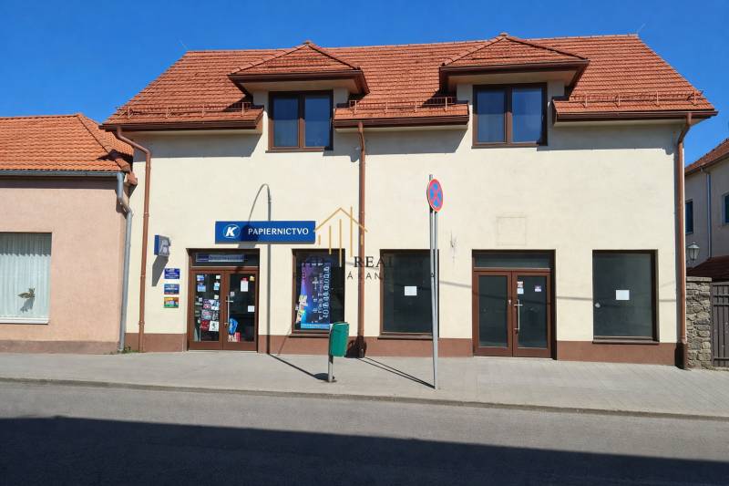 Obchodní prostory na Obchodní ulici v Krupině se šikmou střechou a výlohami.