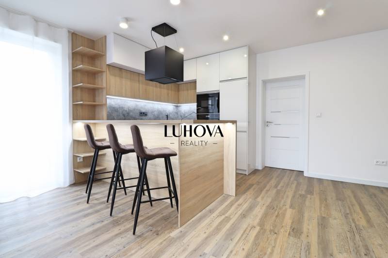 Kuchyně v 3-pokojovém bytě s barovým pultem a podlahou s dřevěným dekorem.