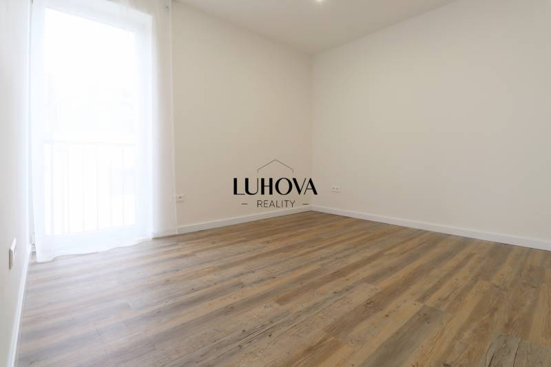 Pokoj v 3-pokojovém bytě s podlahou s dřevěným dekorem a jednoduchým designem.