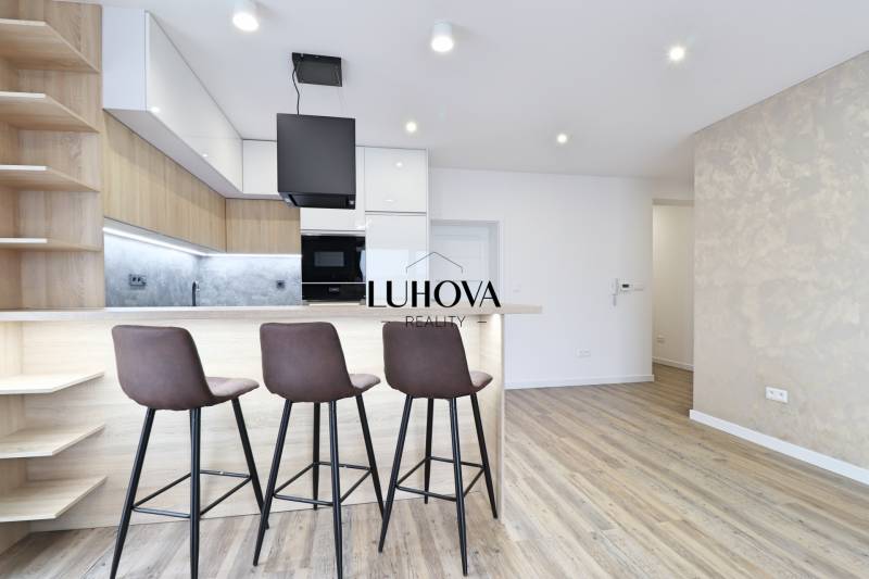 Kuchyně s barovým pultem a podlahou s dřevěným dekorem ve 3pokojovém bytě.